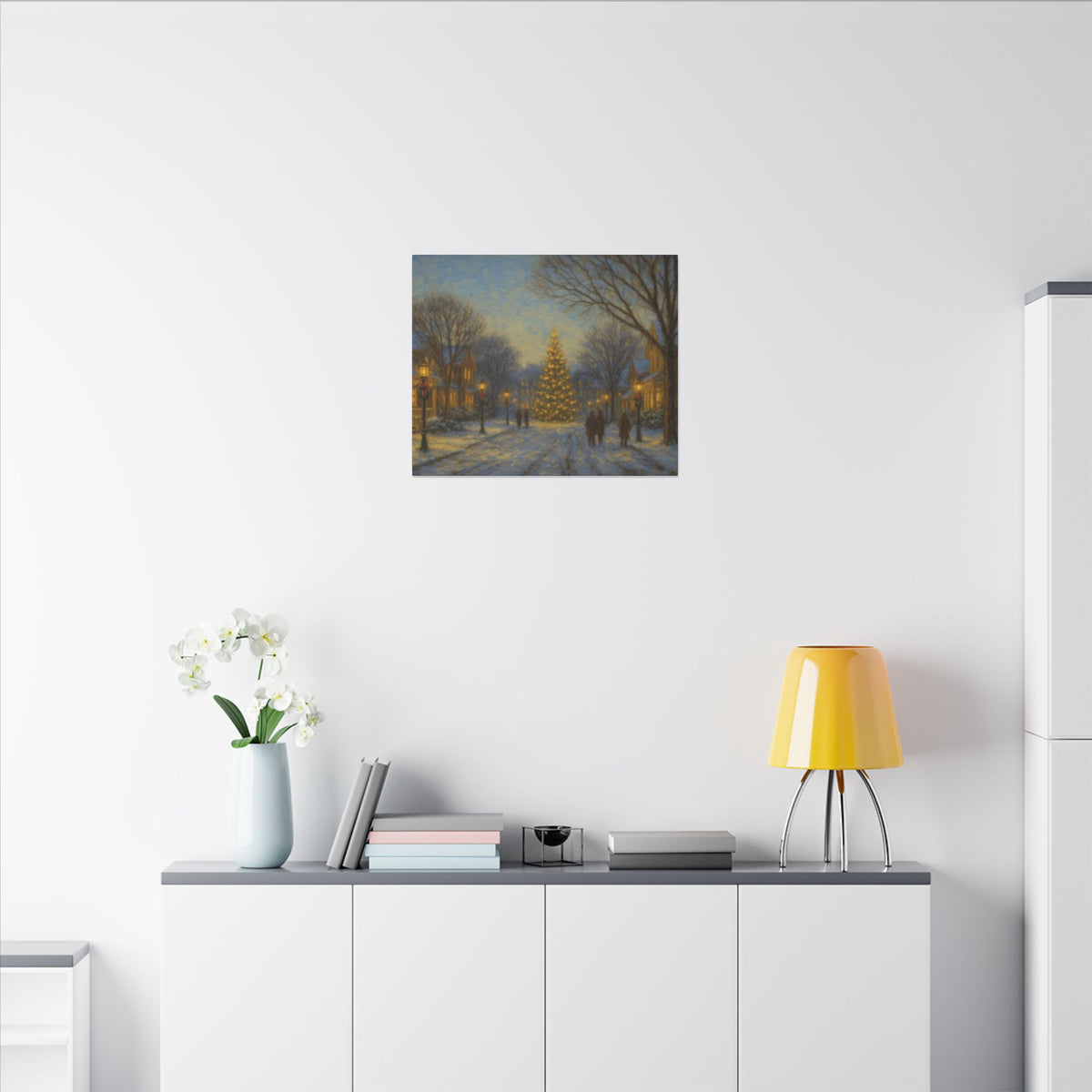 Modern interior with a painting of a snowy street scene, yellow lamp, and white vase with flowers on a shelf.