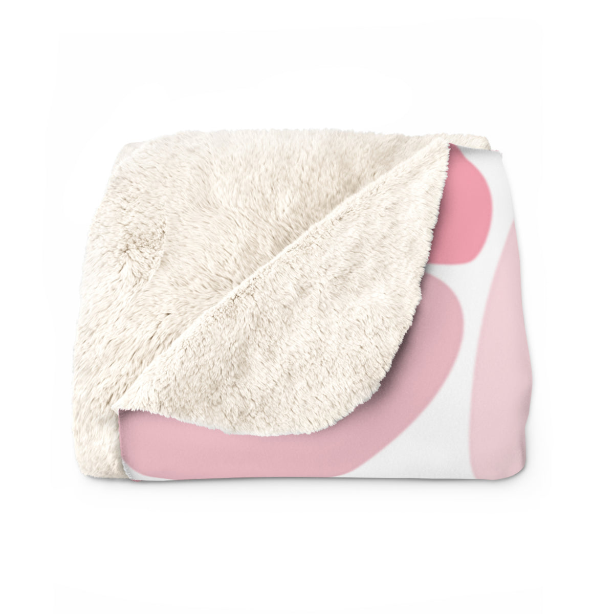 Folded blanket with white sherpa side and pink geometric pattern on a white background