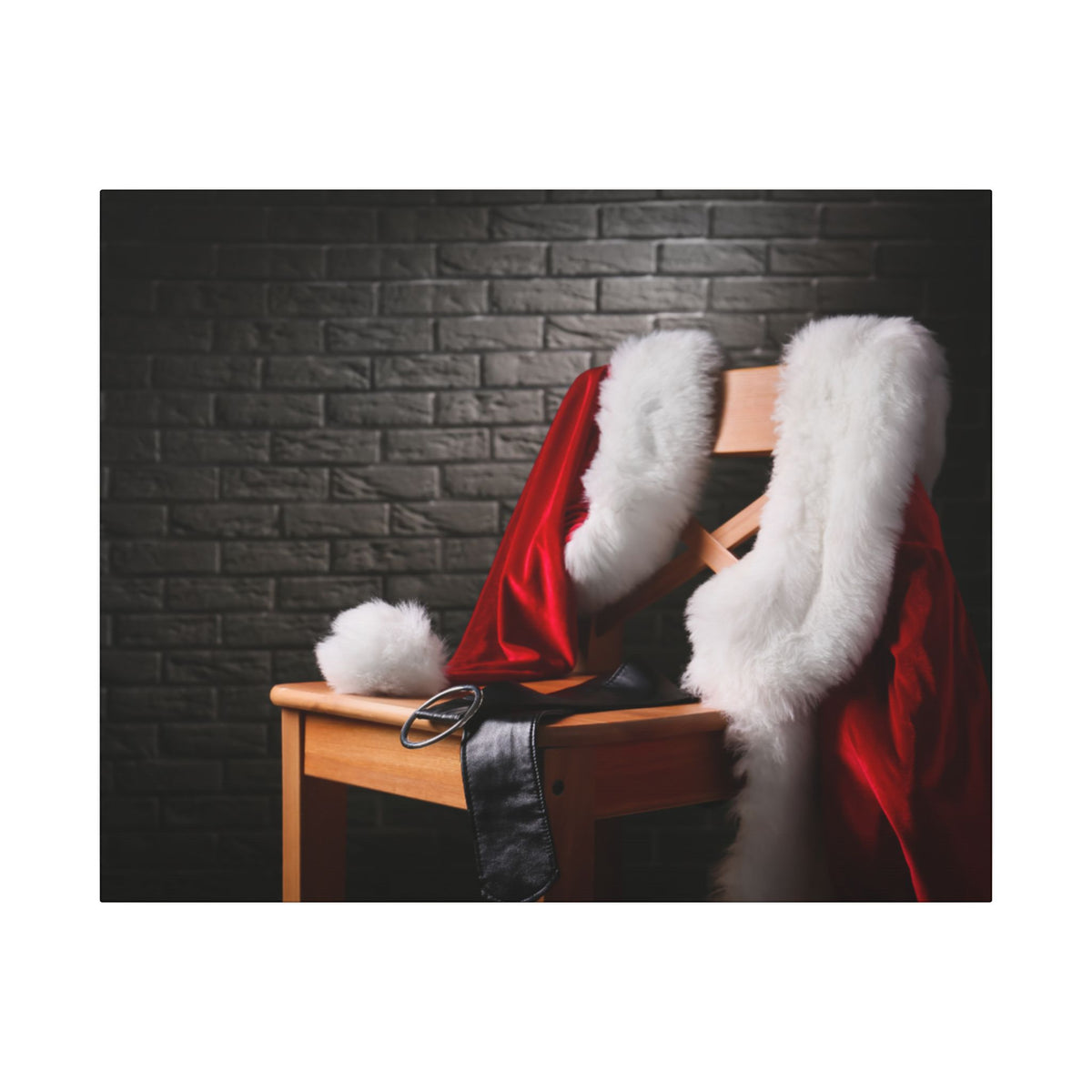 Red Santa Claus coat with white fur trim on a wooden chair against a dark brick wall.
