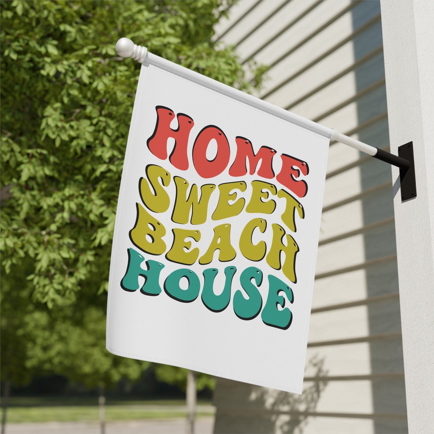 Decorative flag with 'Home Sweet Beach House' text on a house exterior.