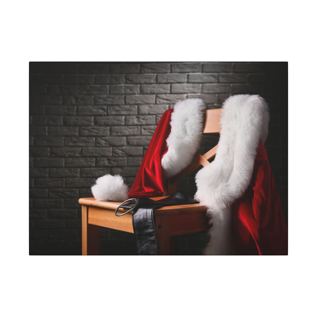 Santa Claus costume with red jacket, white fur trim, and black belt on a wooden chair against a dark brick wall.