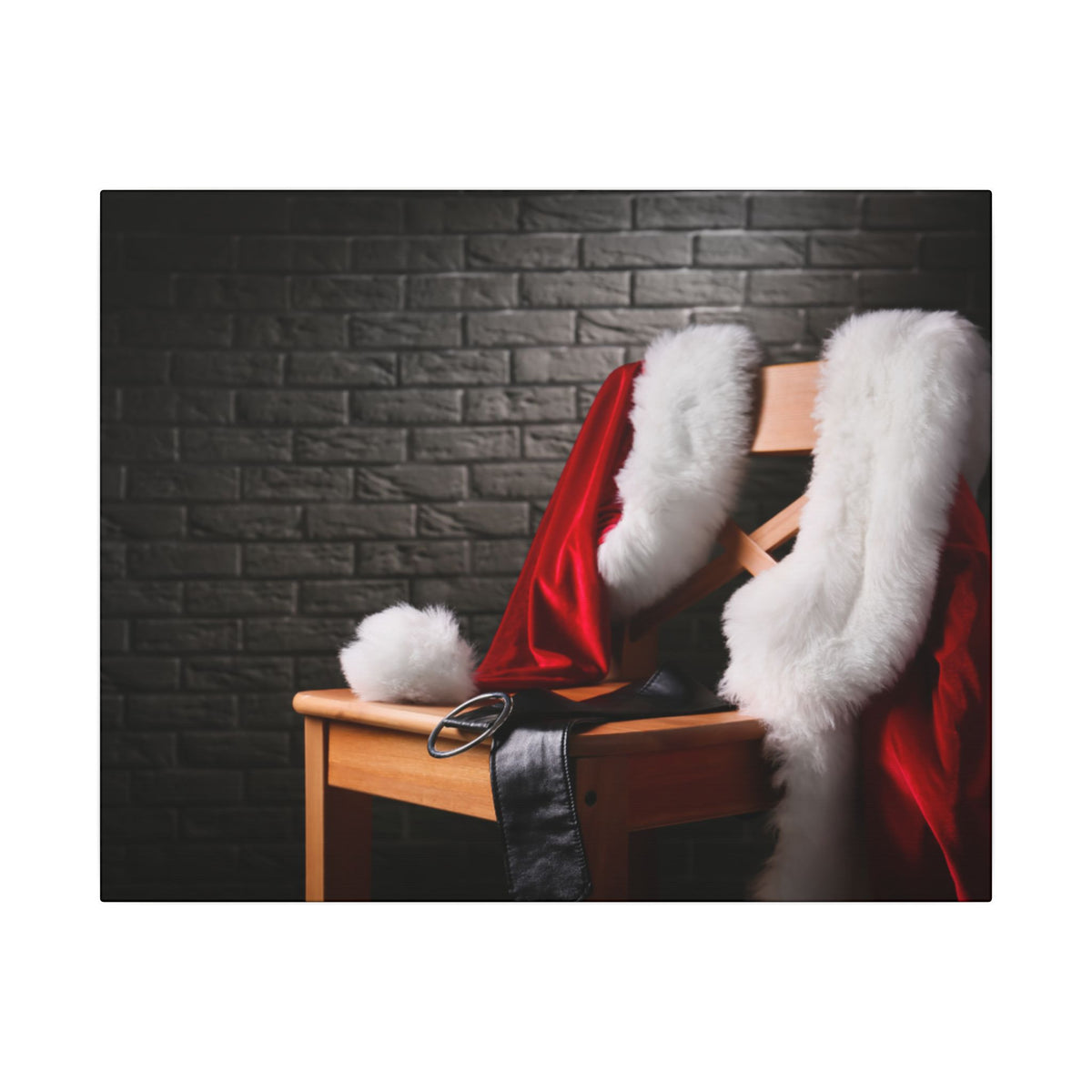 Santa Claus costume with red jacket, white fur trim, and black shoes on a wooden chair against a dark brick wall.