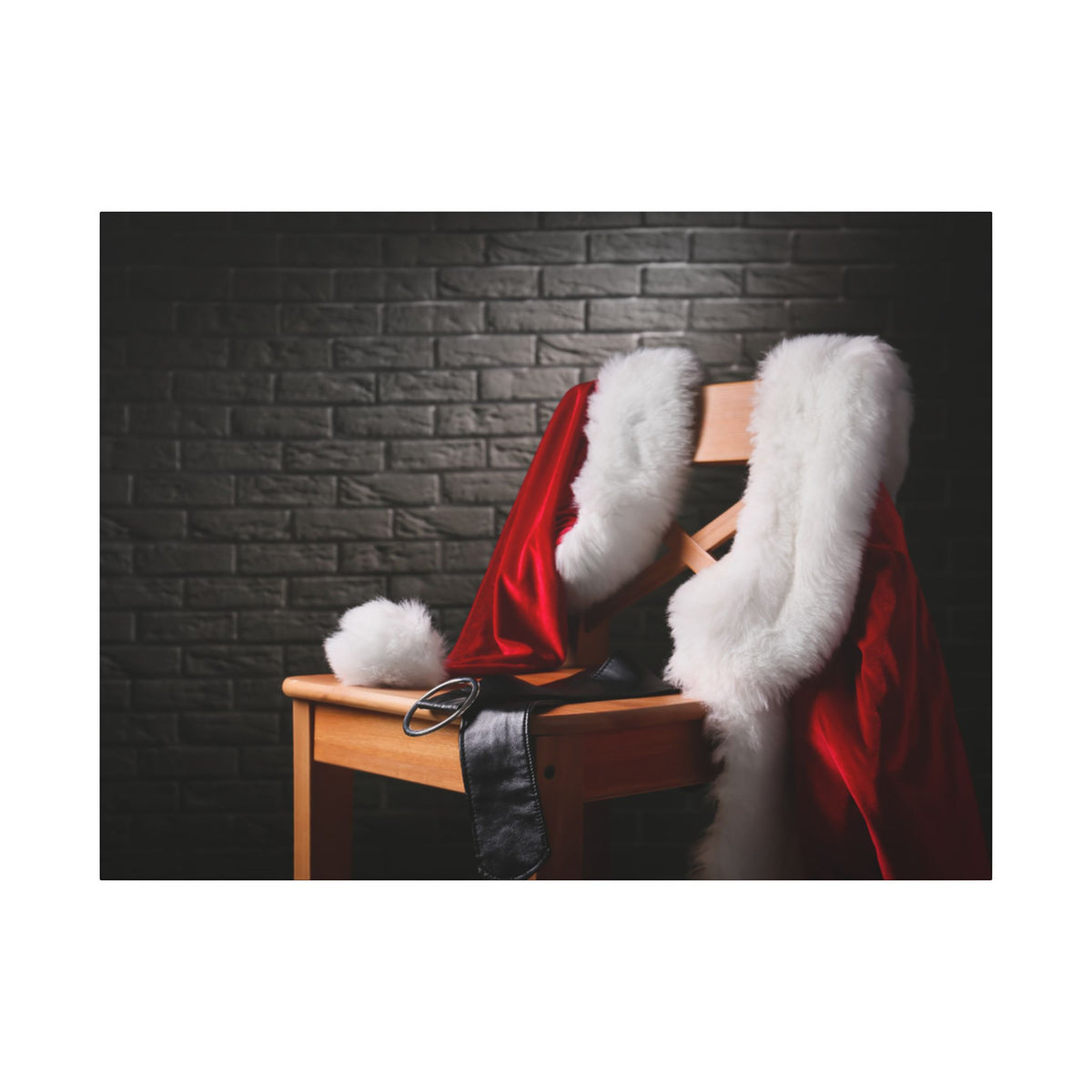 Red Santa Claus coat with white fur trim draped over a wooden chair against a dark brick wall.