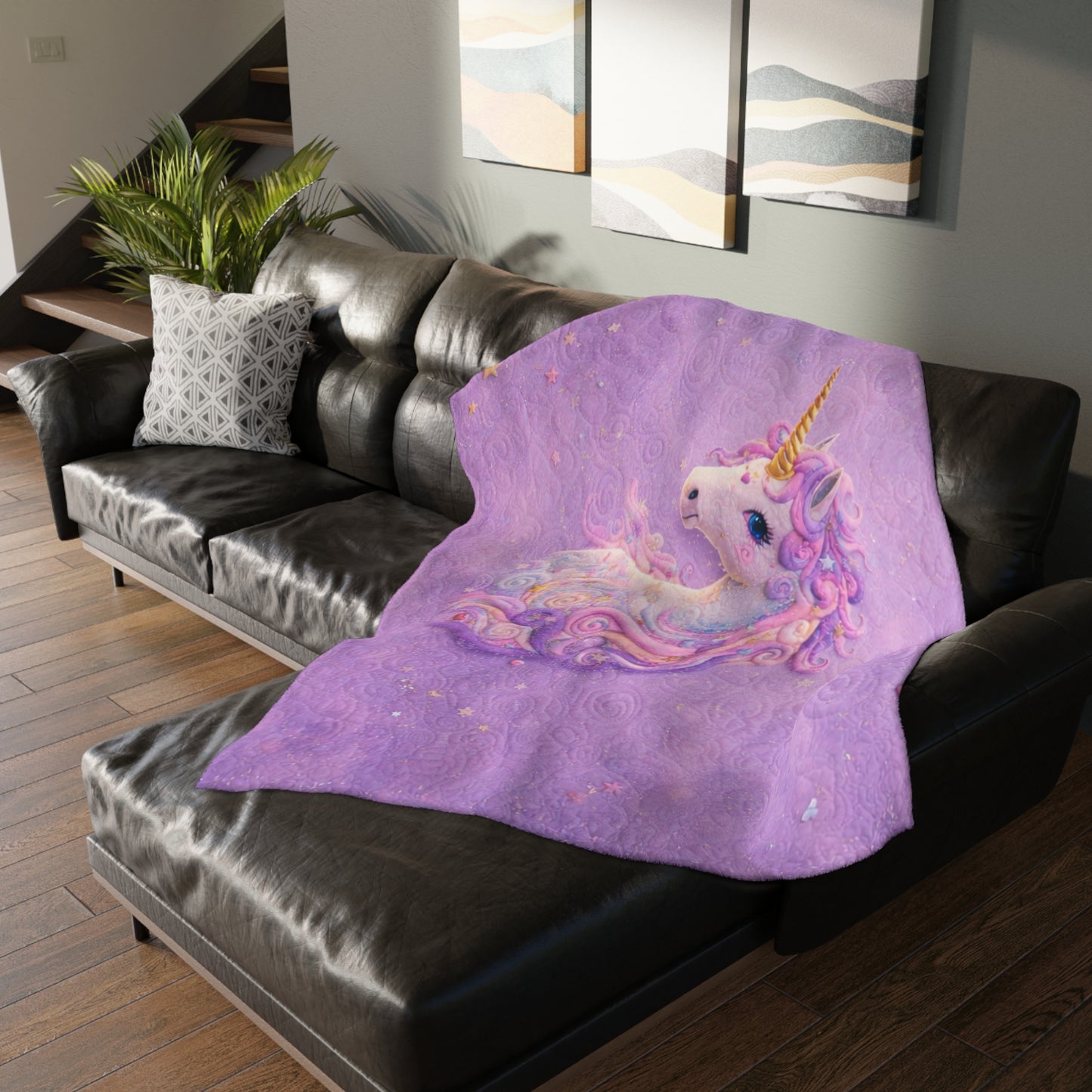 Purple unicorn blanket on a black couch in a living room setting