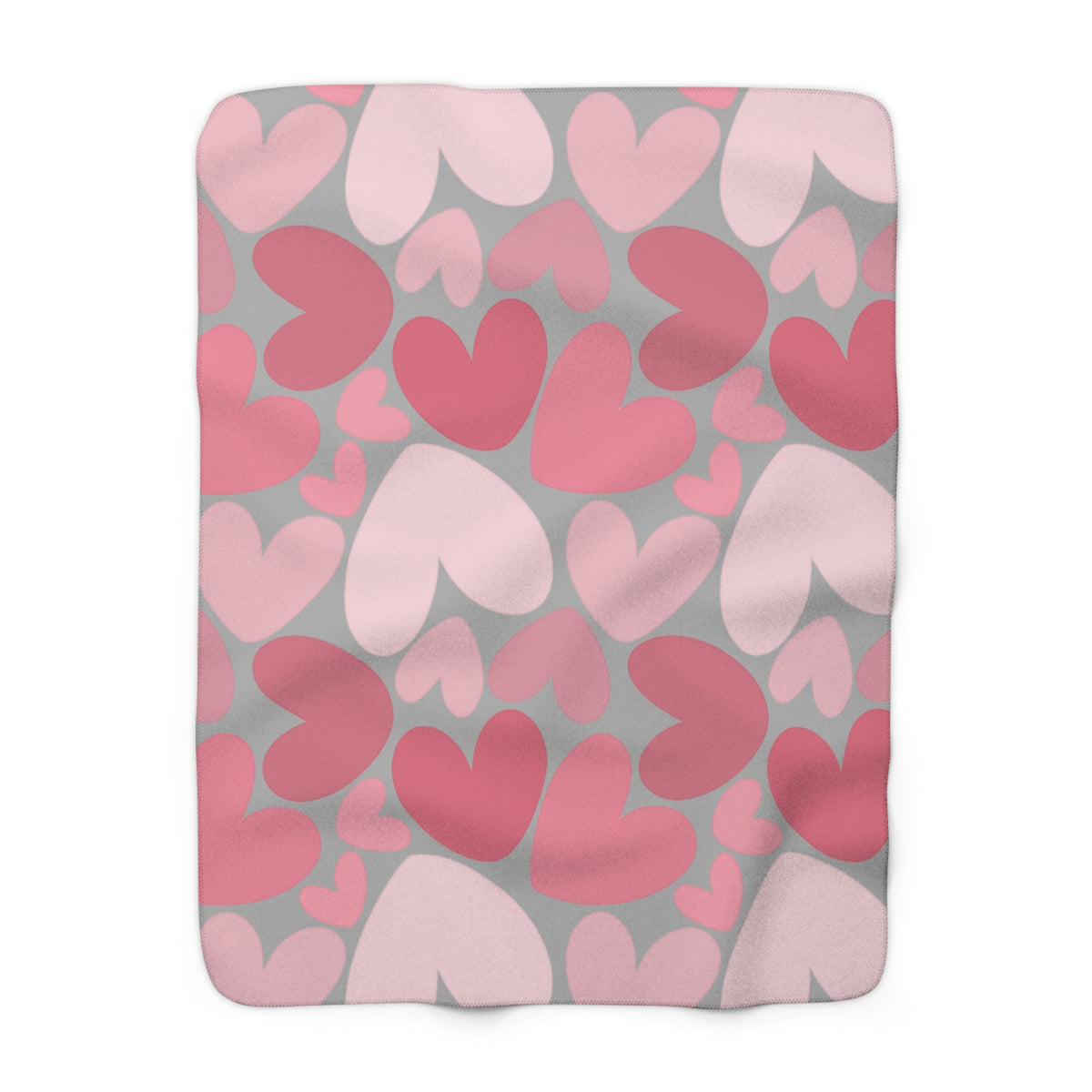 Fleece blanket with pink and red heart pattern on gray background