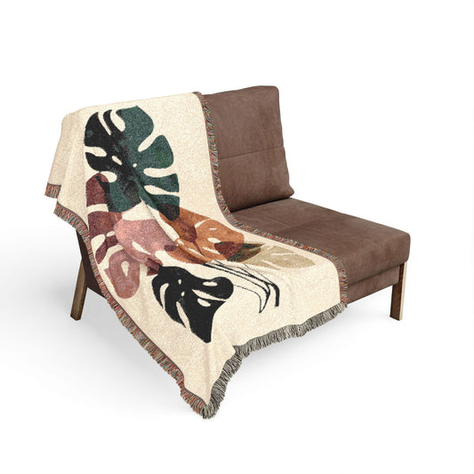 Brown chair with a leaf-patterned blanket draped over it on a white background