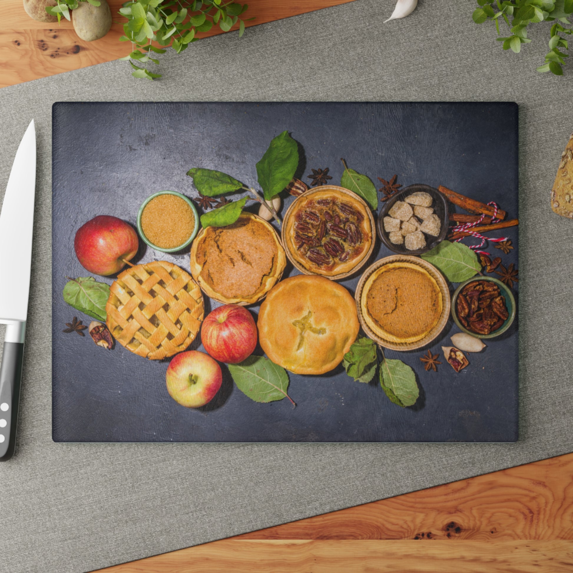 Decorative cutting board with pies and fruits on a gray surface