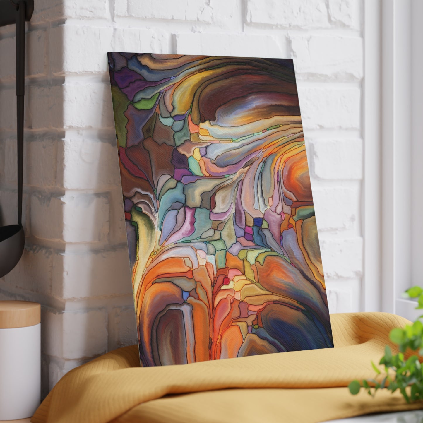 Colorful abstract painting leaning against a white brick wall.