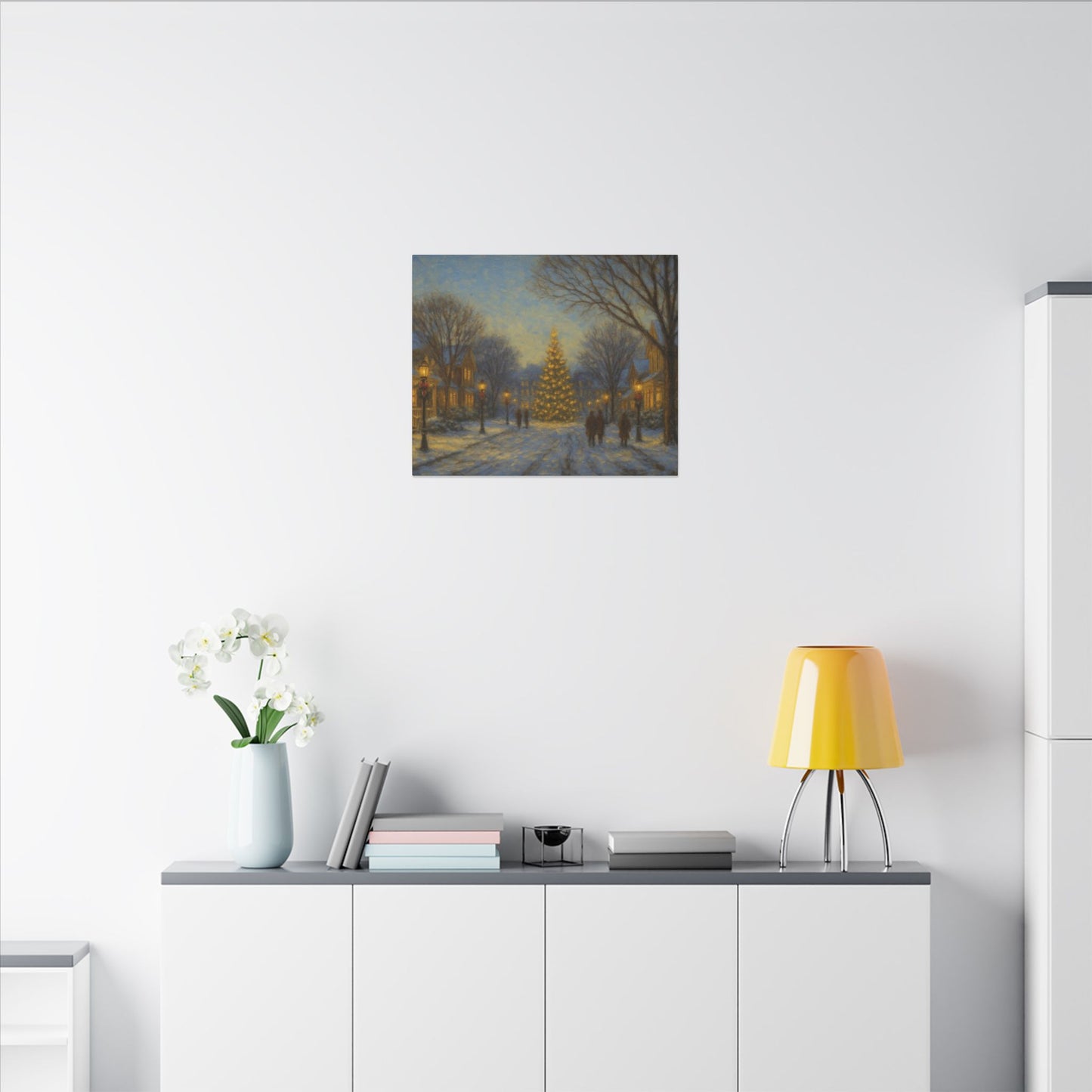 Modern interior with a painting of a snowy street scene, yellow lamp, and white vase with flowers on a shelf.