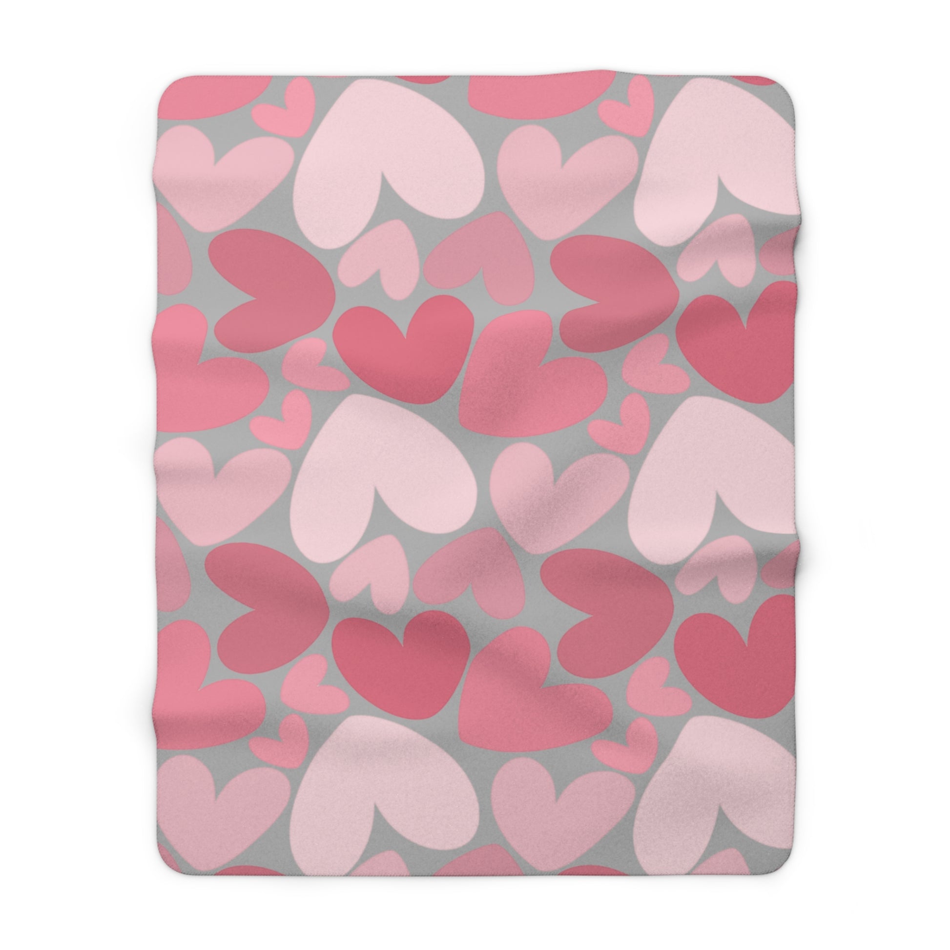 Fleece blanket with pink and red heart pattern on gray background