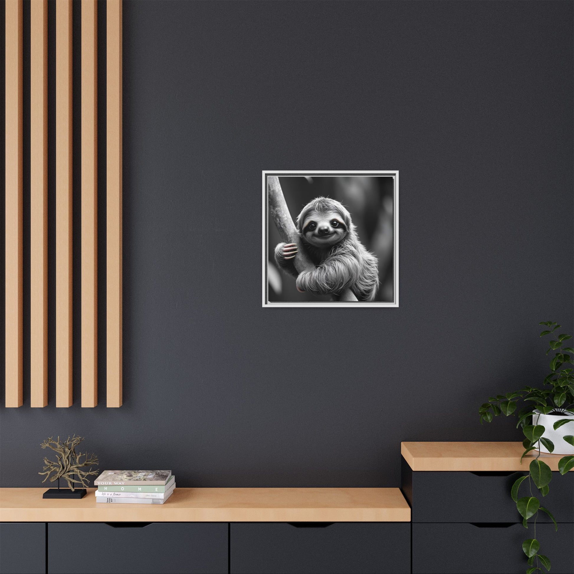 Framed black and white sloth print on a dark wall with wooden shelves and decor.