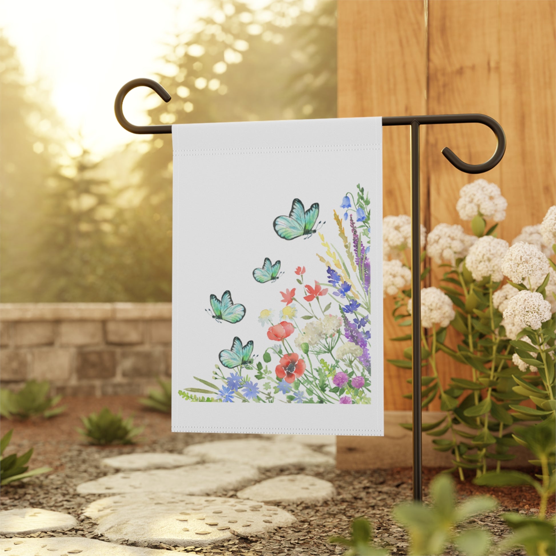 Decorative garden flag with butterflies and flowers on a stand outdoors.