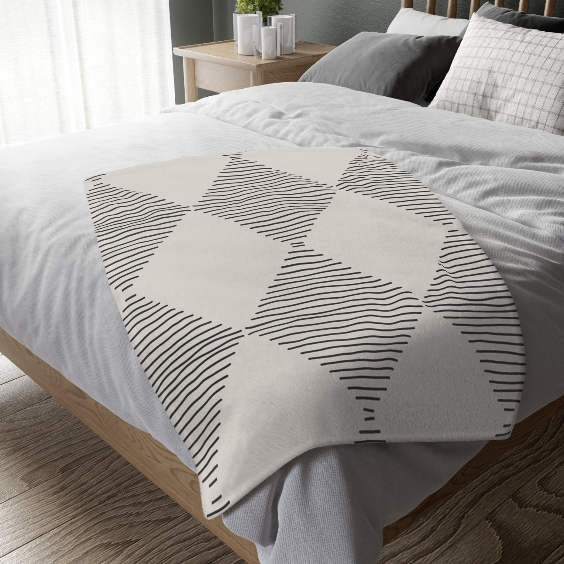 Neatly made bed with geometric patterned blanket in a bedroom setting