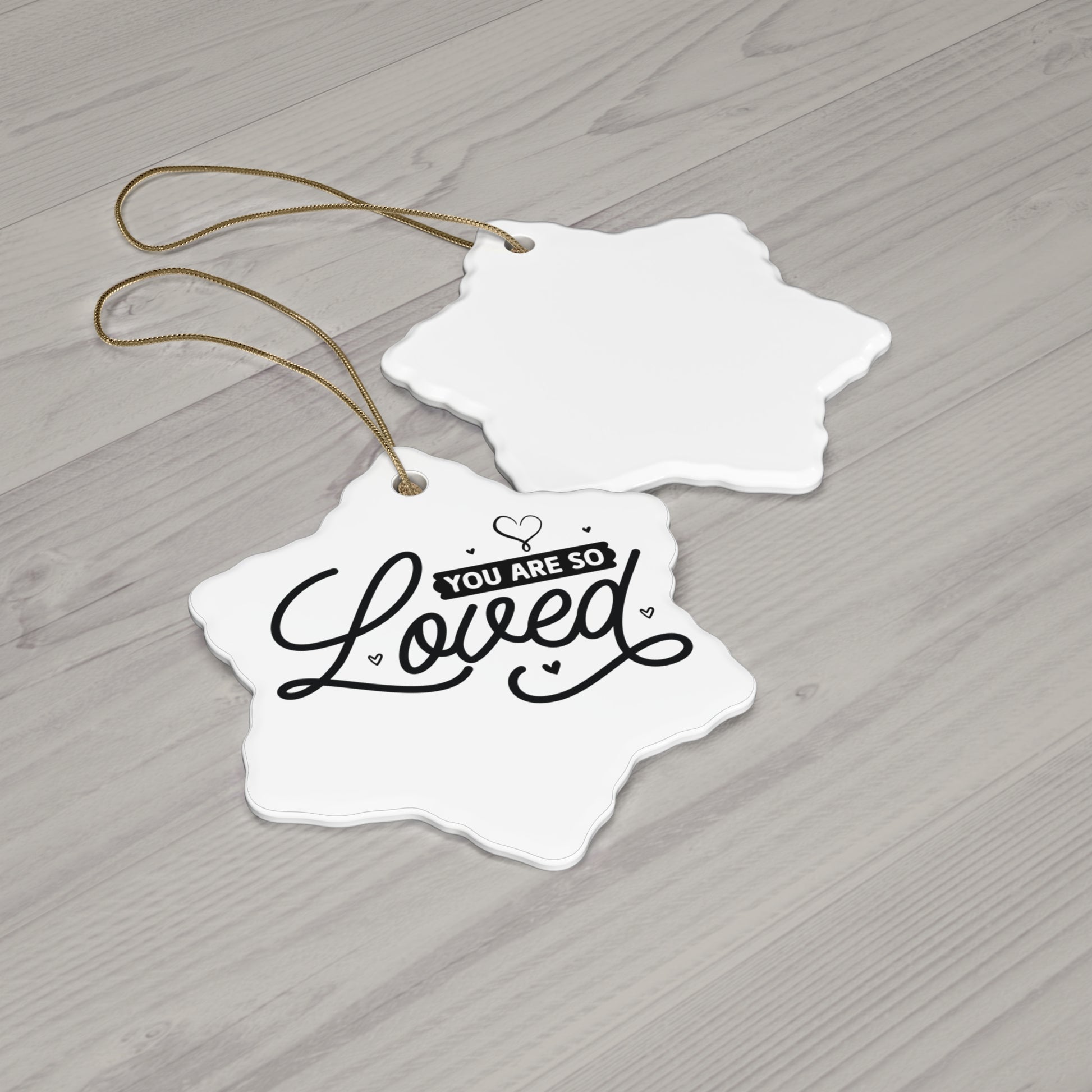 Decorative tags with 'You are so loved' text on a wooden surface