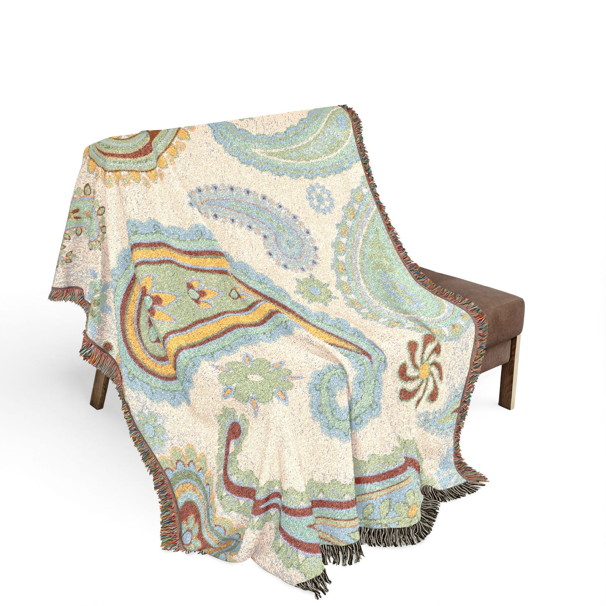 Decorative throw blanket with paisley pattern draped over a chair on a white background