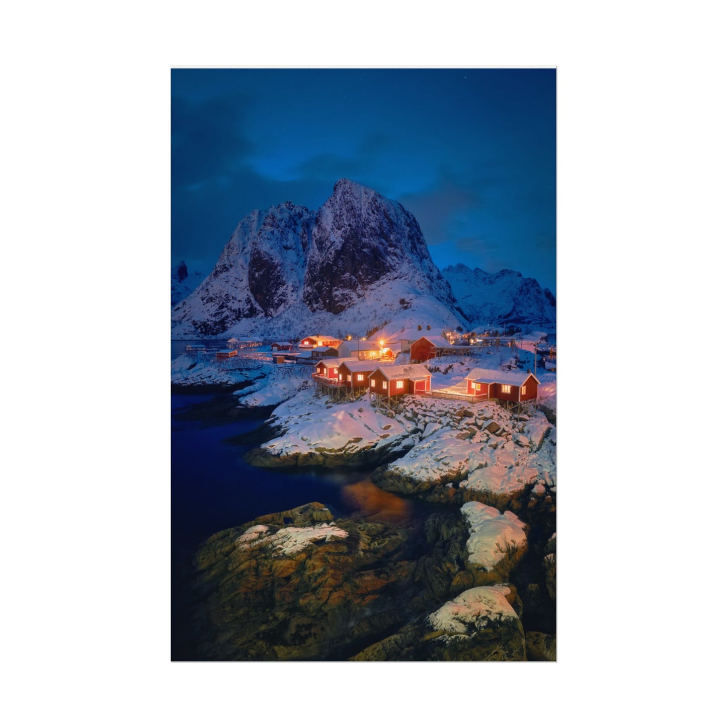 Snowy mountain landscape with illuminated buildings at night