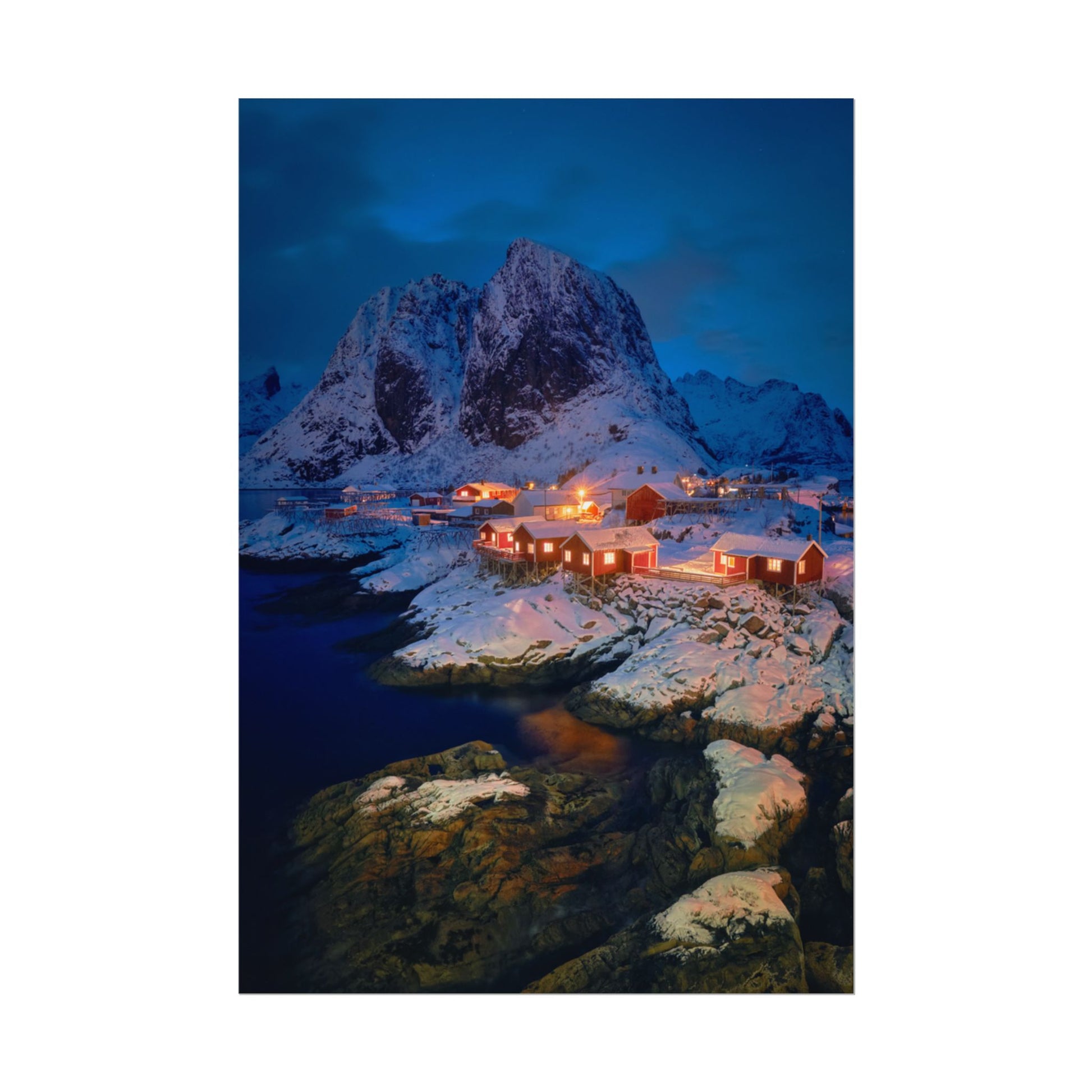 Snowy mountain landscape with illuminated buildings at night