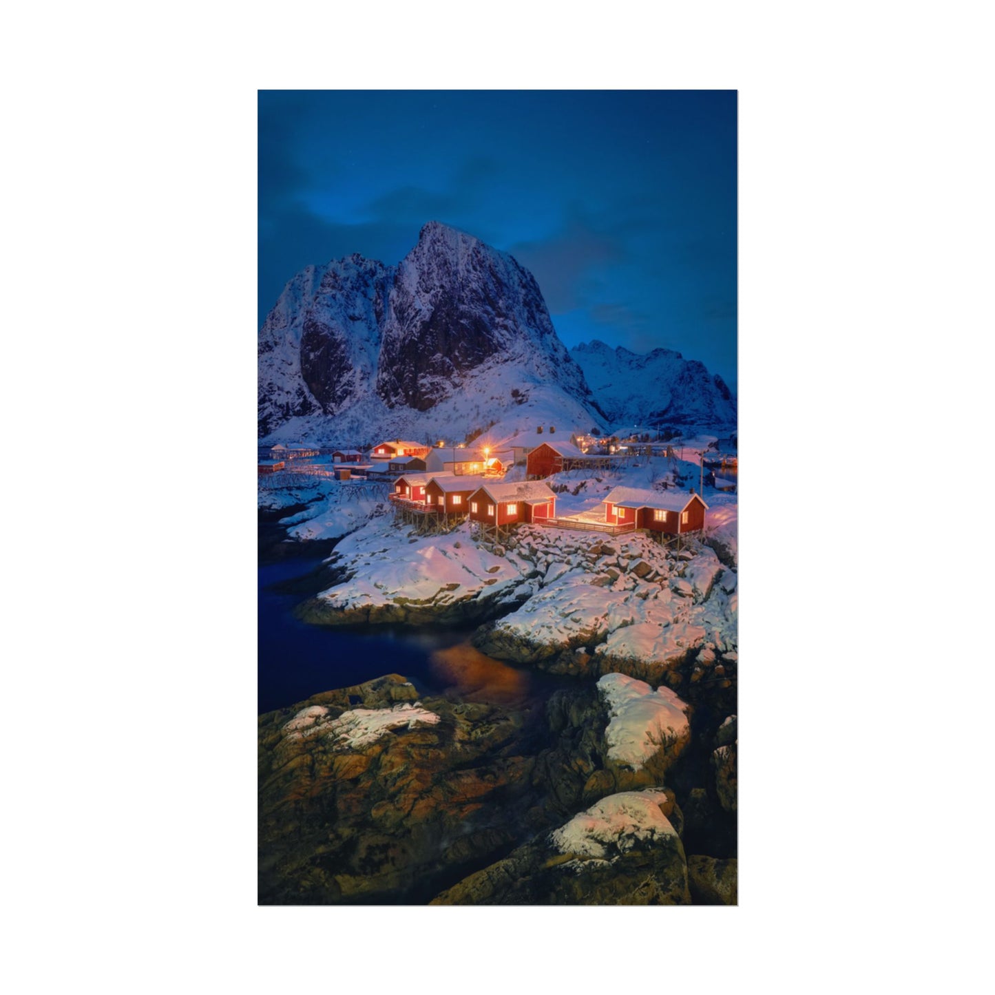 Snowy mountain village with illuminated buildings at night