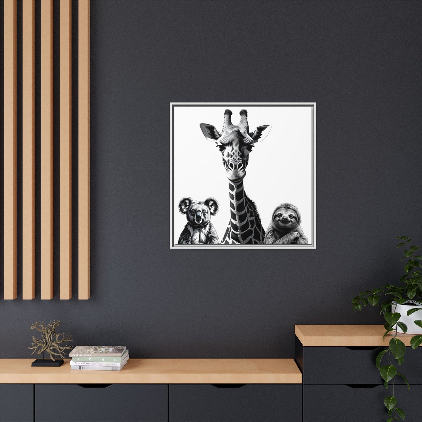 Framed artwork of a giraffe with two sloths on a dark wall.