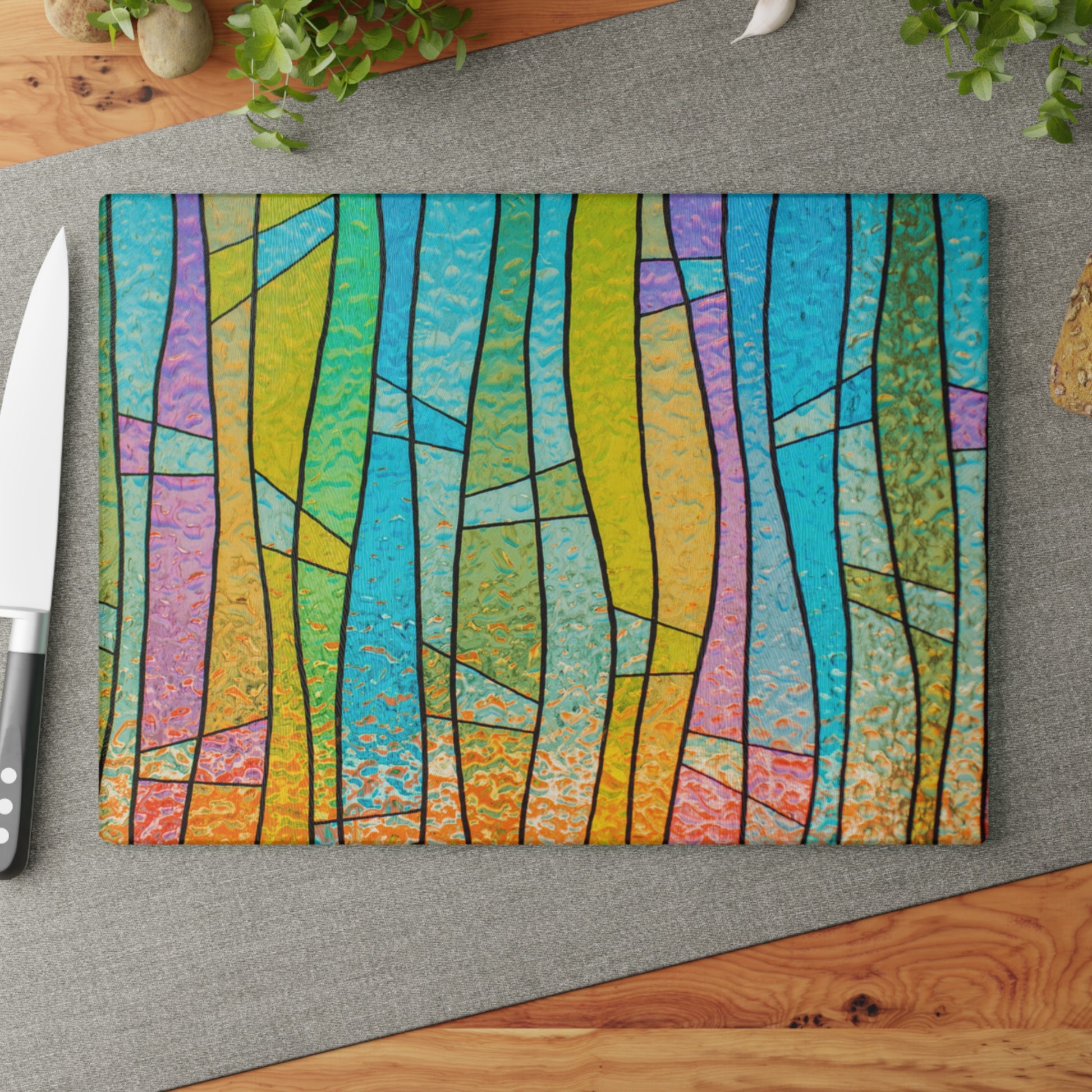 Colorful abstract design on a cutting board with a knife on a gray surface.