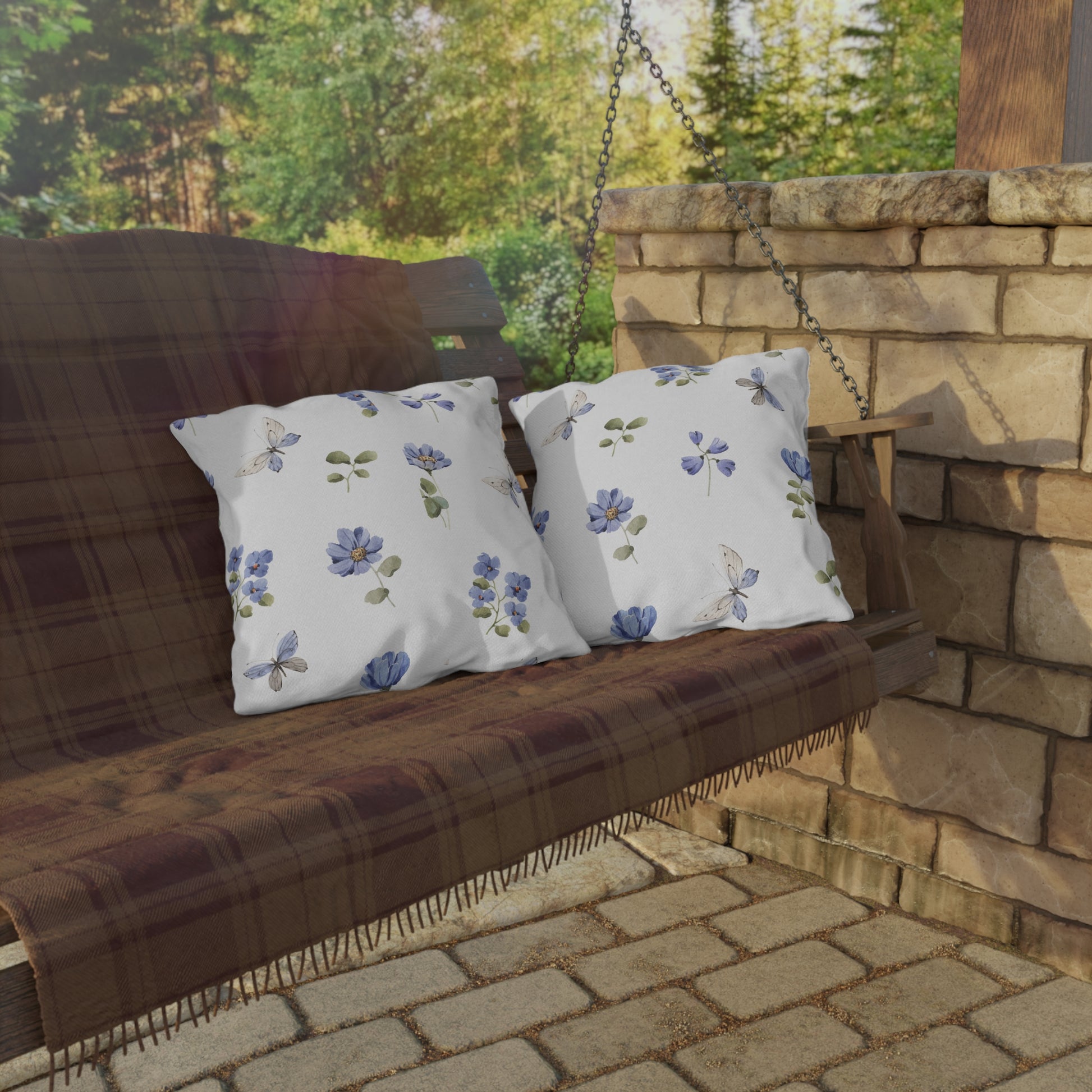 Wooden swing with floral-patterned cushions on a stone patio