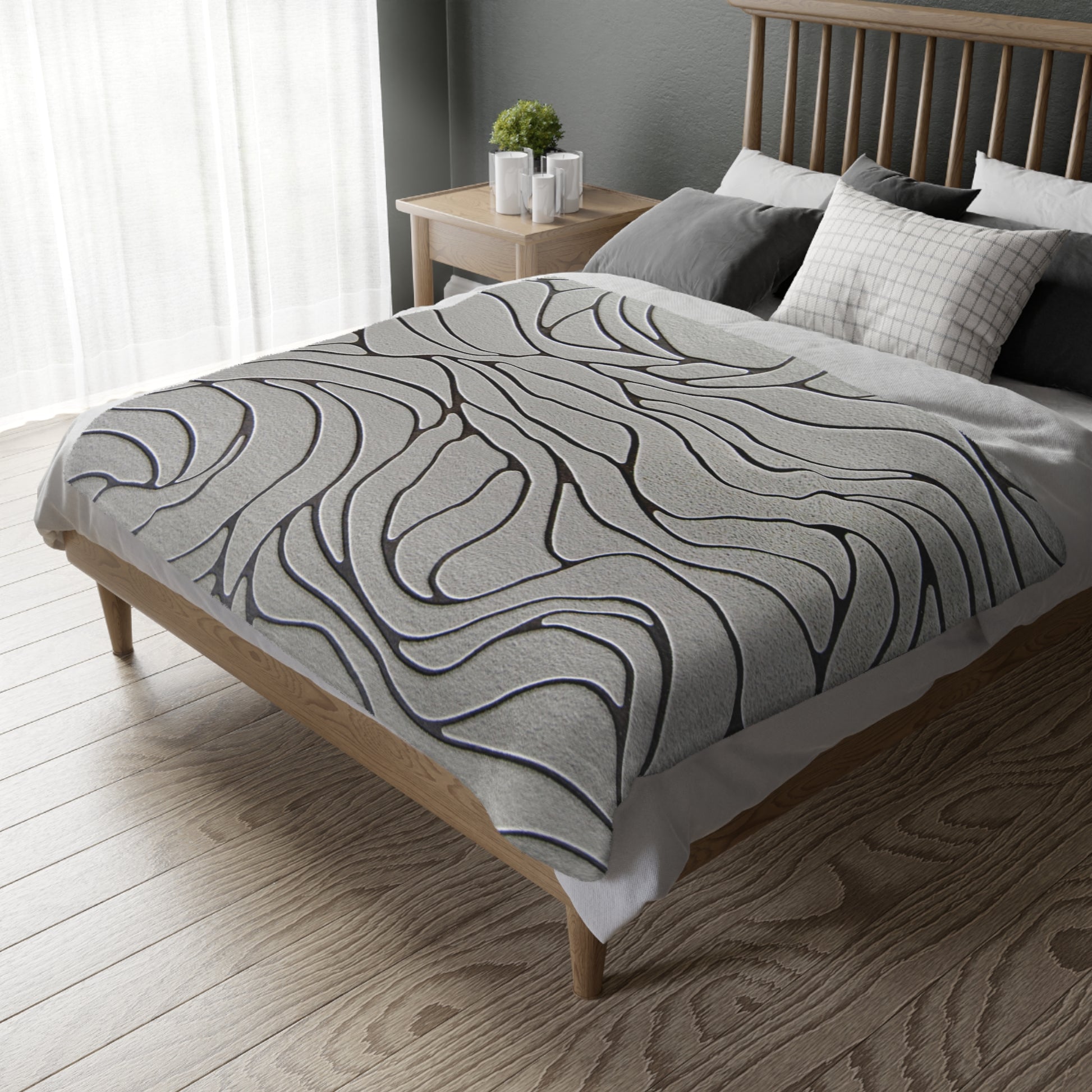 Bed with a gray patterned comforter in a bedroom setting