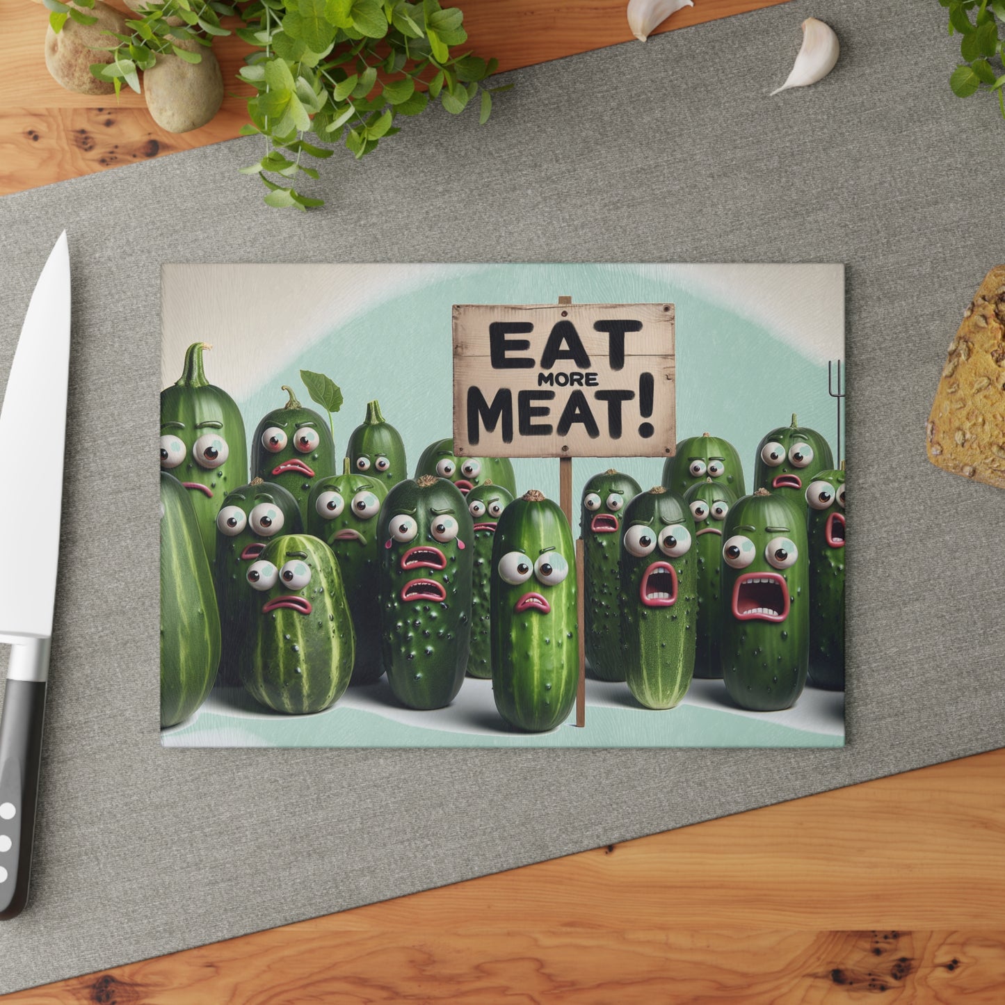 Cartoon cucumbers with faces holding a 'Eat More Meat!' sign on a kitchen counter.