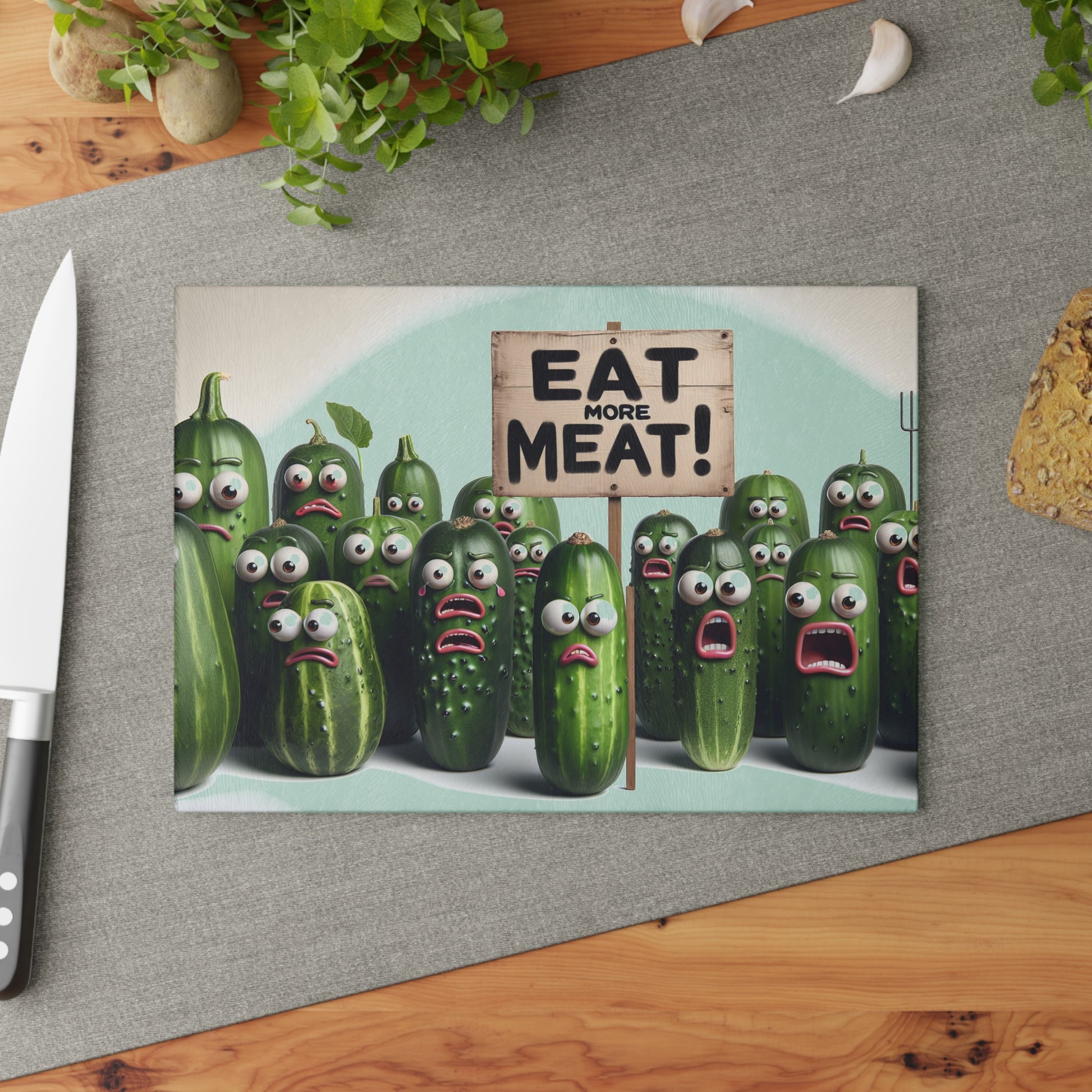 Cartoon cucumbers with faces holding a 'Eat More Meat!' sign on a kitchen counter.