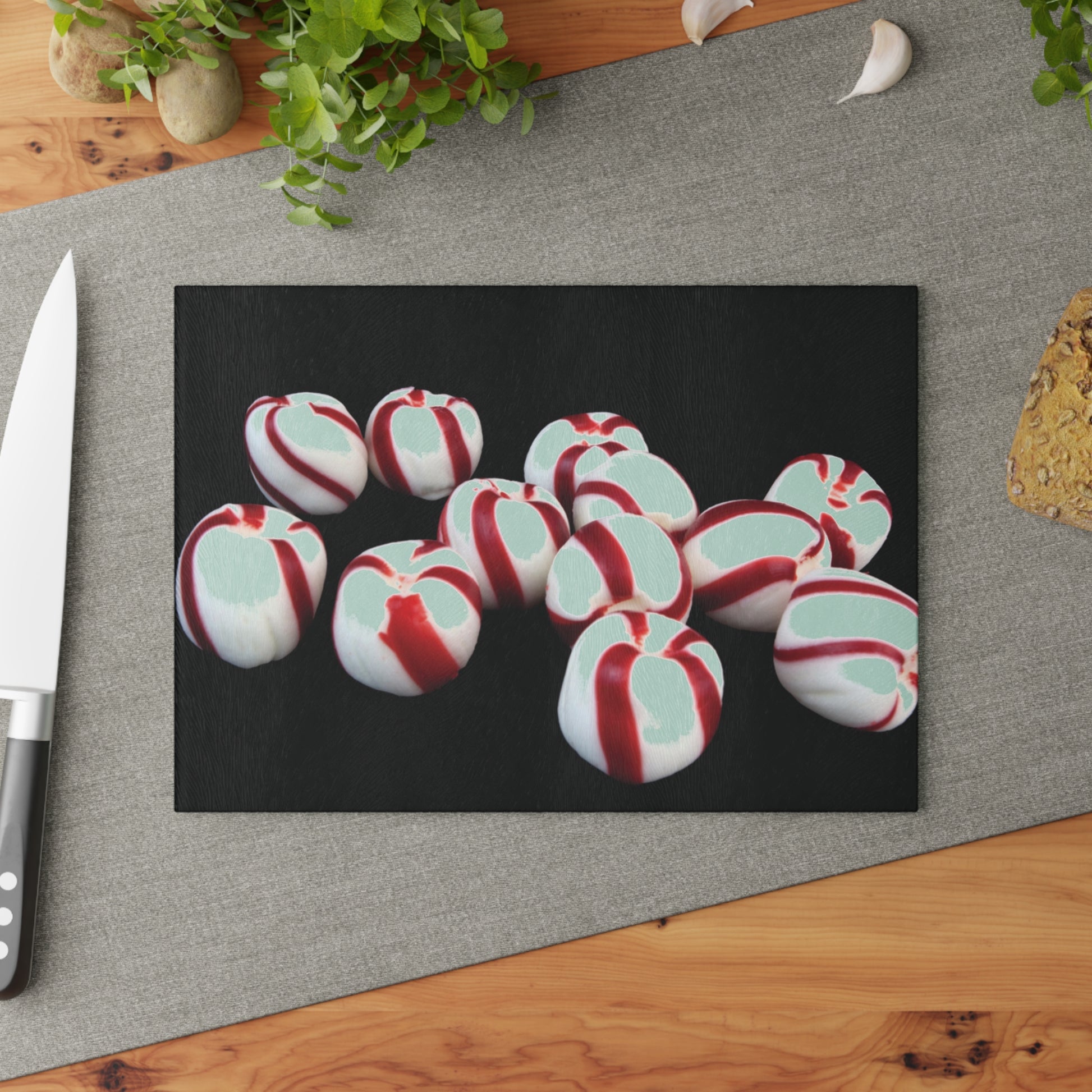 Peppermint candies on a black card with a knife and cutting board in the background