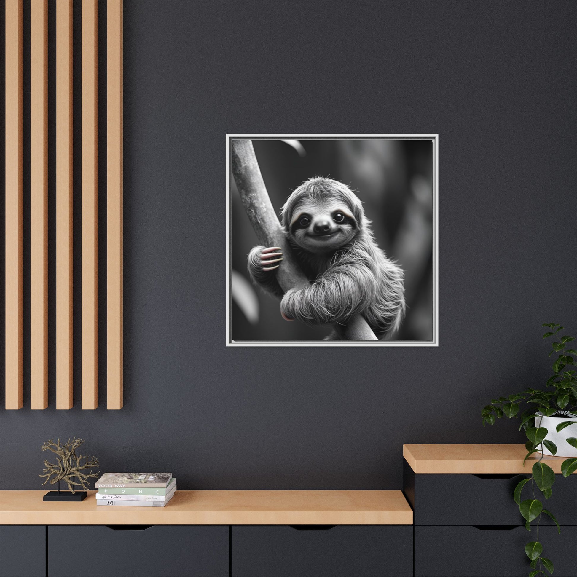Framed black and white sloth print on a dark wall with wooden shelves and decor.