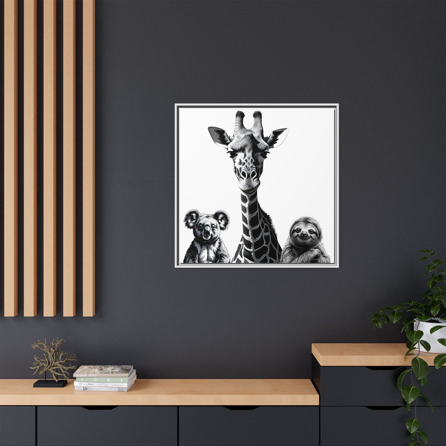 Framed artwork of a giraffe and two sloths on a dark wall with wooden shelves.