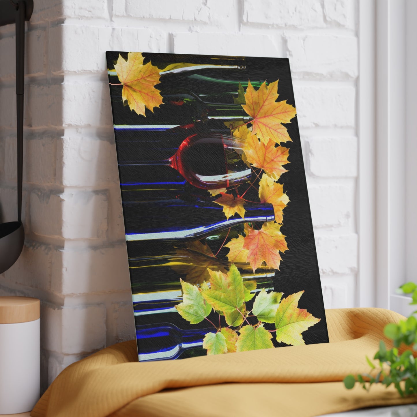 Abstract art piece with colorful leaves on a black background, leaning against a white brick wall.