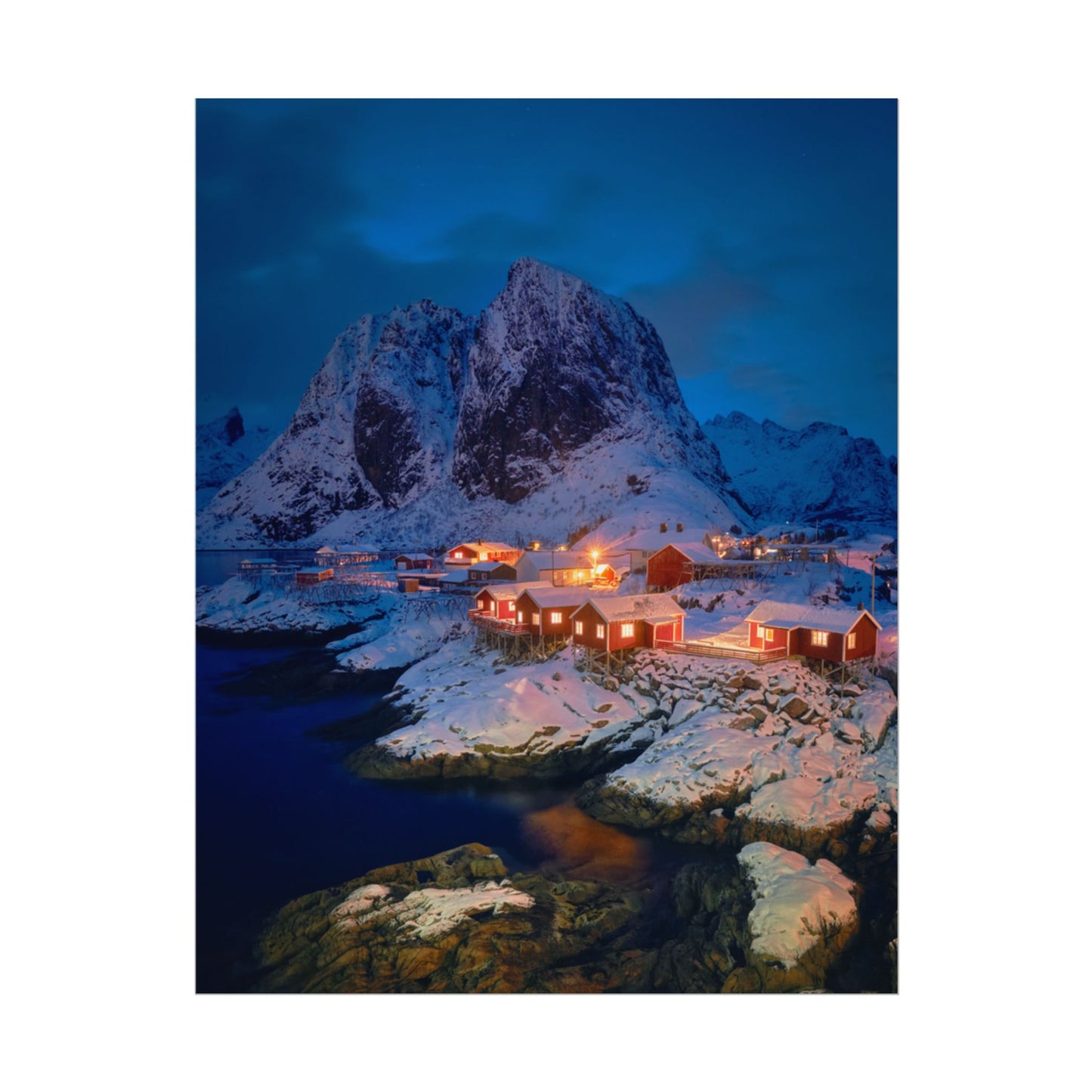 Snowy mountain landscape with illuminated buildings at night