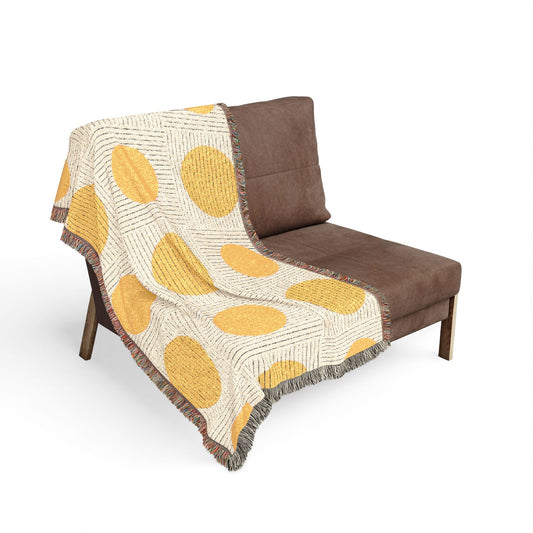 Brown chair with a yellow patterned blanket draped over it on a white background