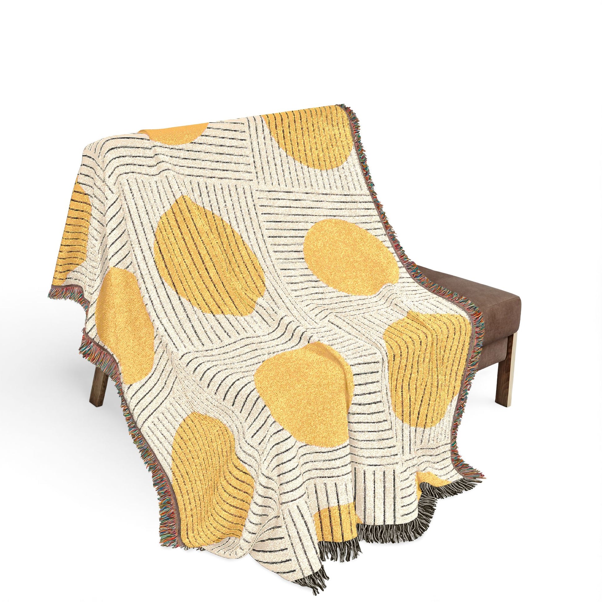 Yellow and beige patterned blanket draped over a chair on a white background