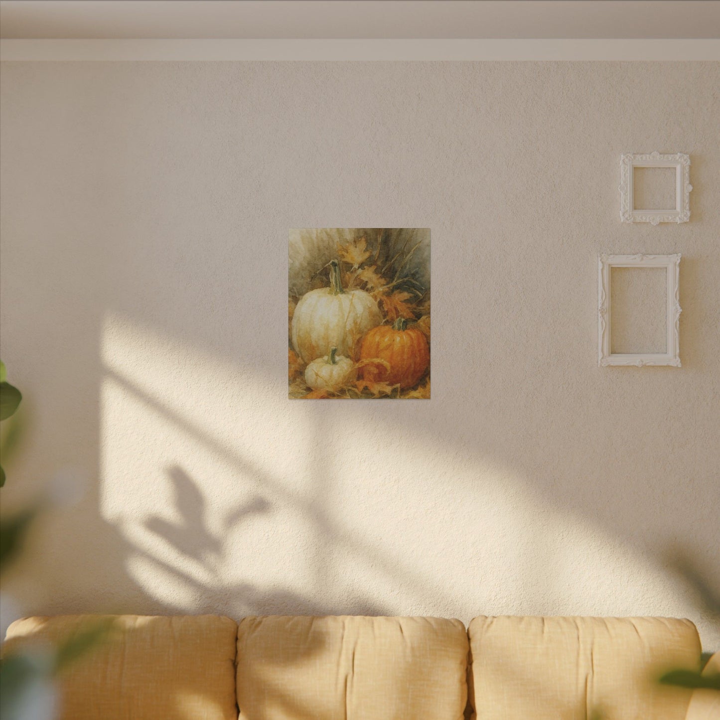 Framed artwork of pumpkins on a wall above a sofa