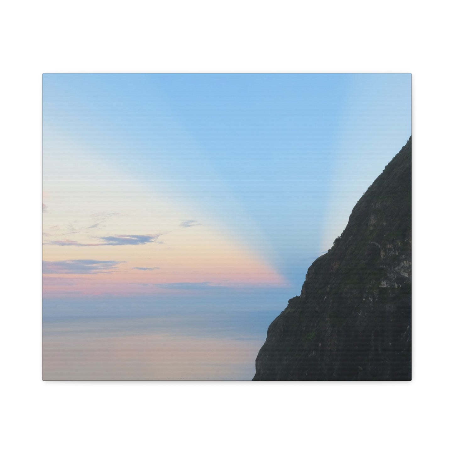 Sunset or sunrise over a cliff with a rainbow in the sky