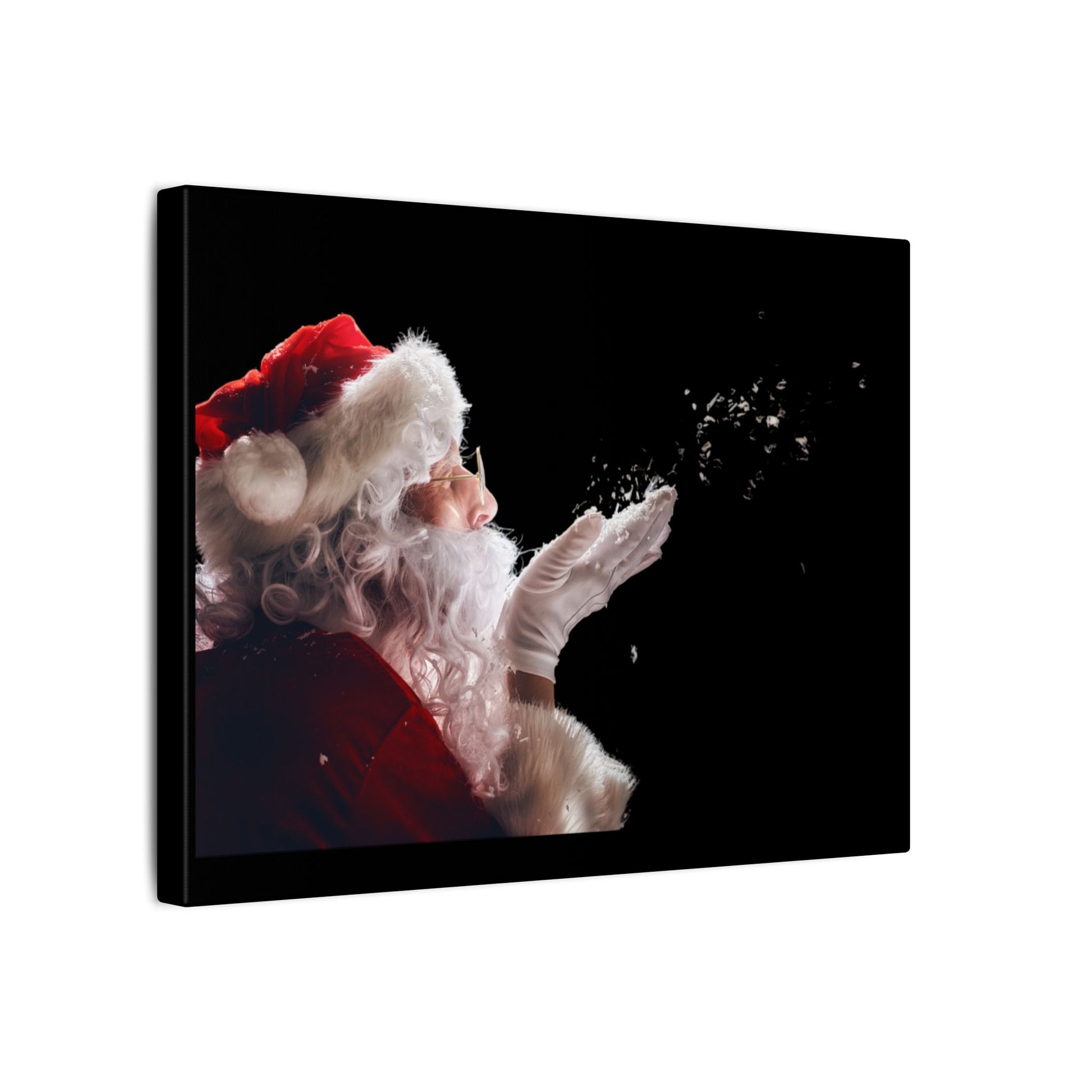 Canvas print of Santa Claus blowing snowflakes against a black background