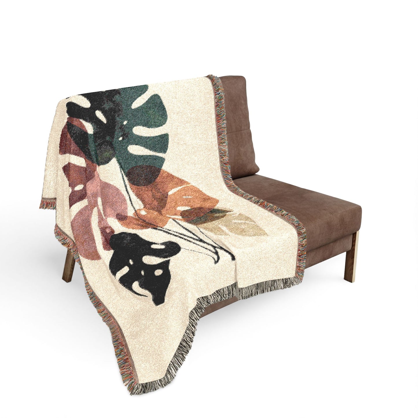 Decorative blanket with leaf pattern draped over a brown chair on a white background