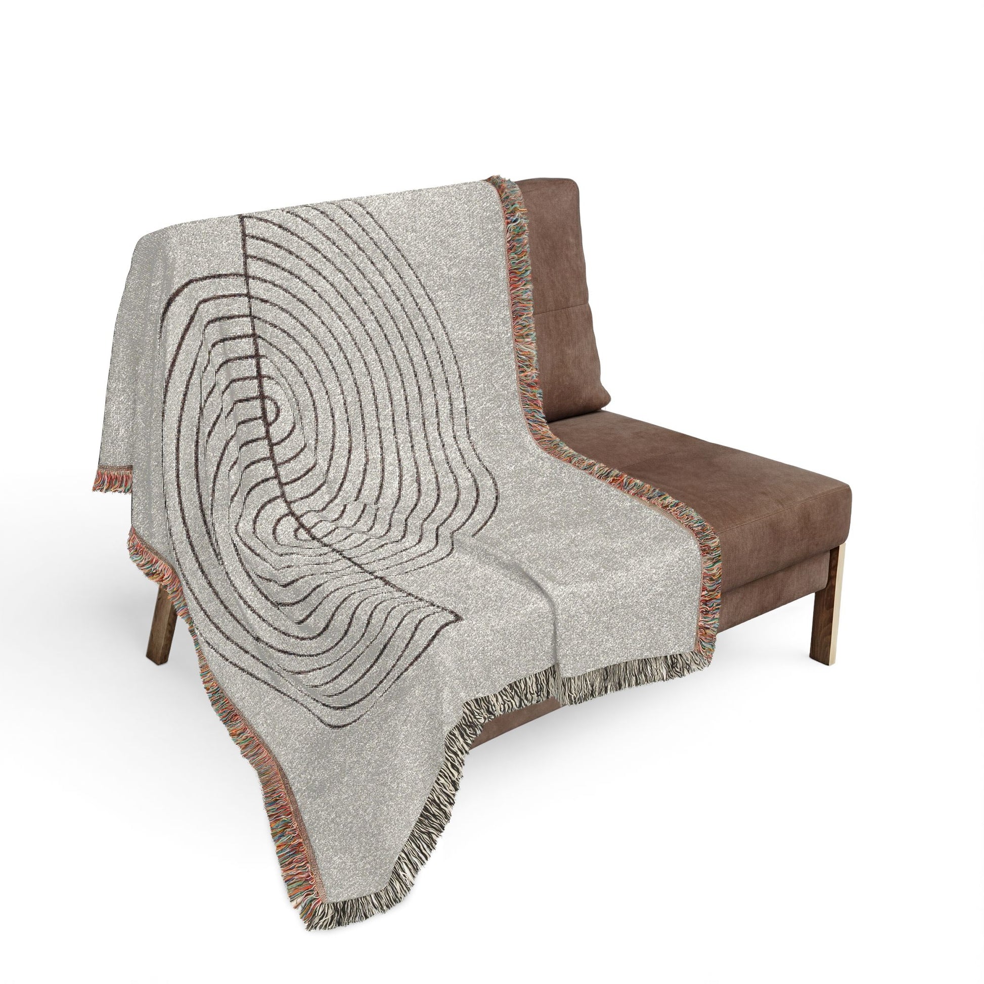 Gray patterned throw blanket draped over a brown chair on a white background