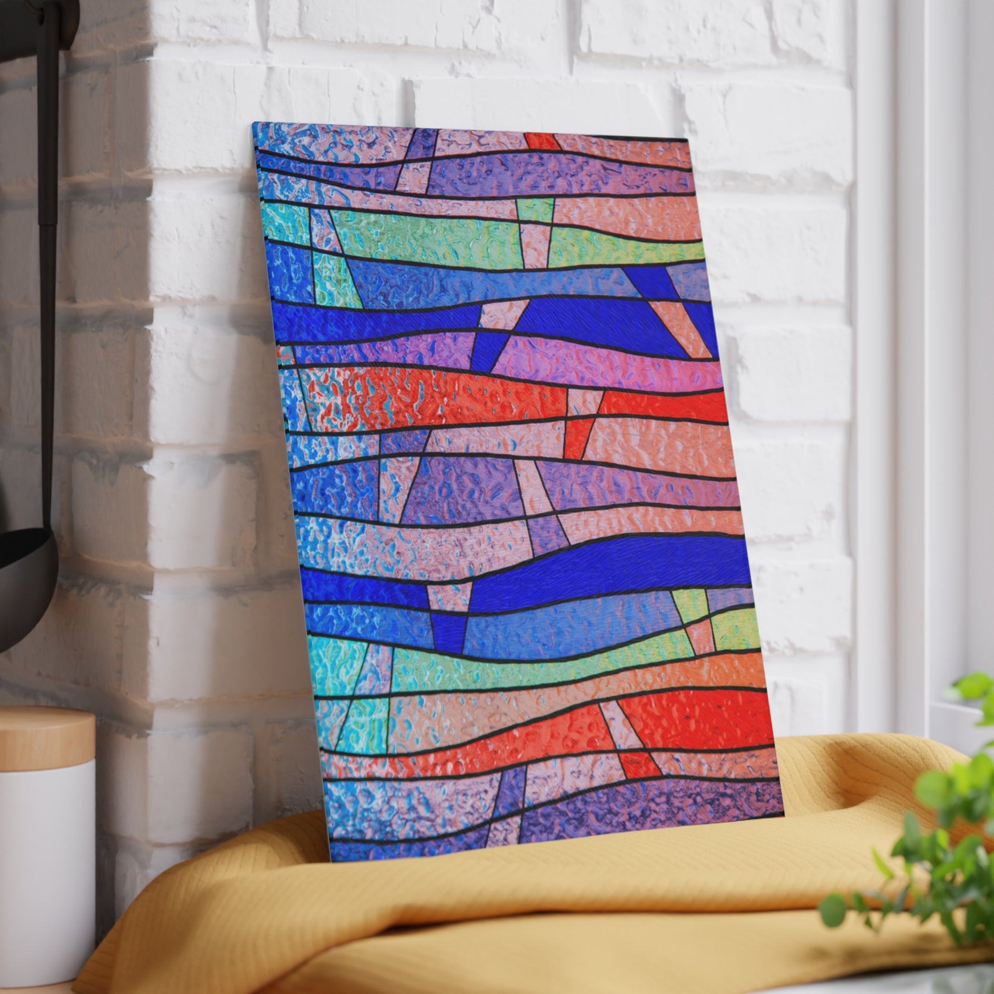 Colorful abstract patterned towel hanging on a white brick wall.