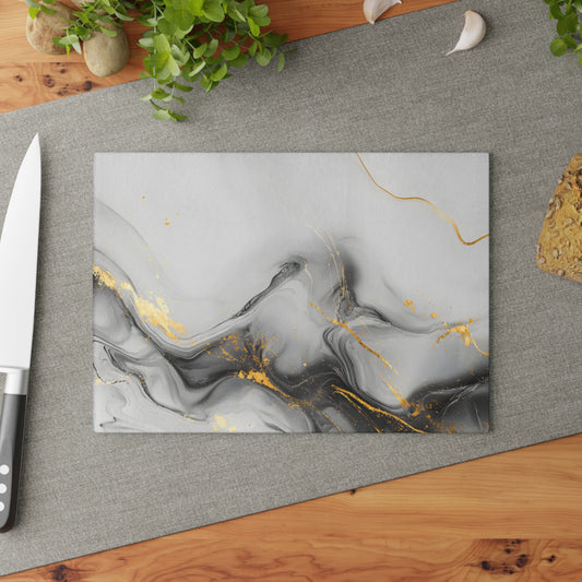 Marble-patterned cutting board with gold accents on a gray surface, surrounded by kitchen items.