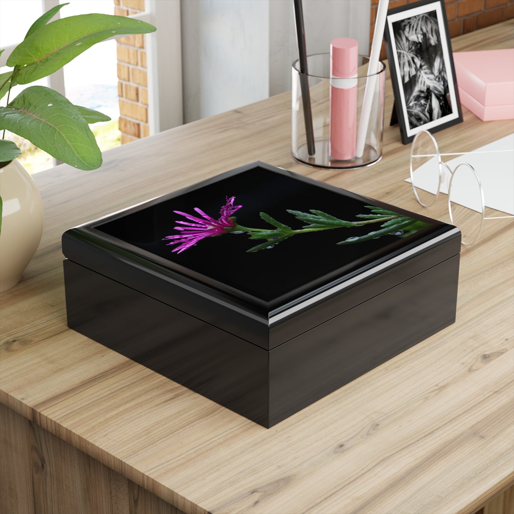 Black decorative box with a floral design on a wooden surface