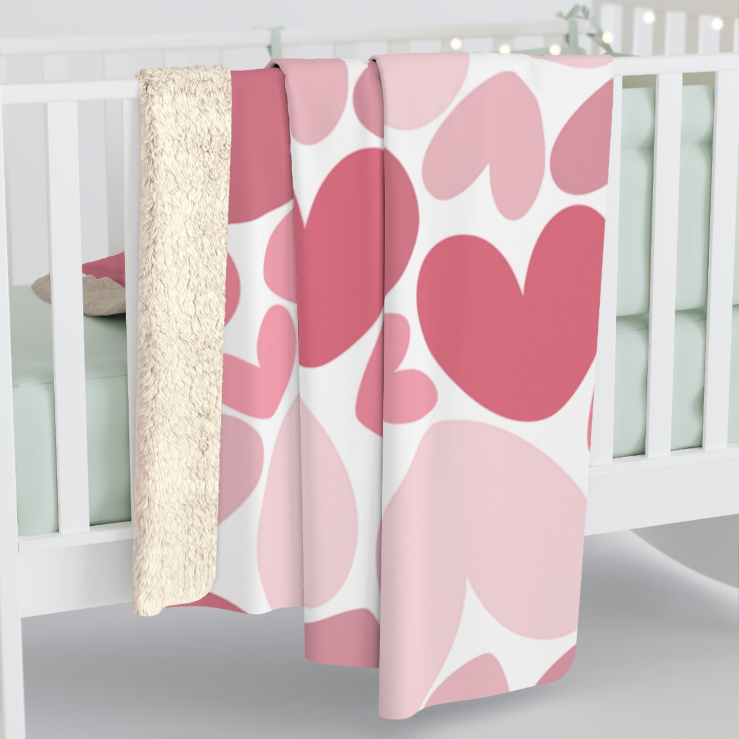Pink and white patterned crib sheet on a crib