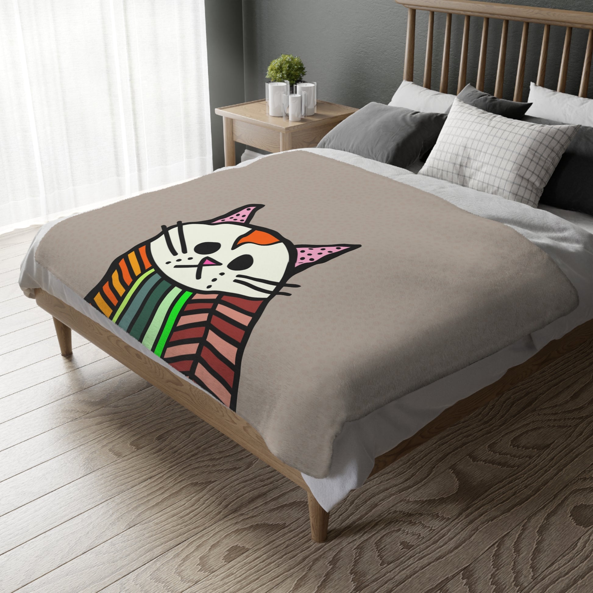 Bed with a colorful cat design blanket in a bedroom setting