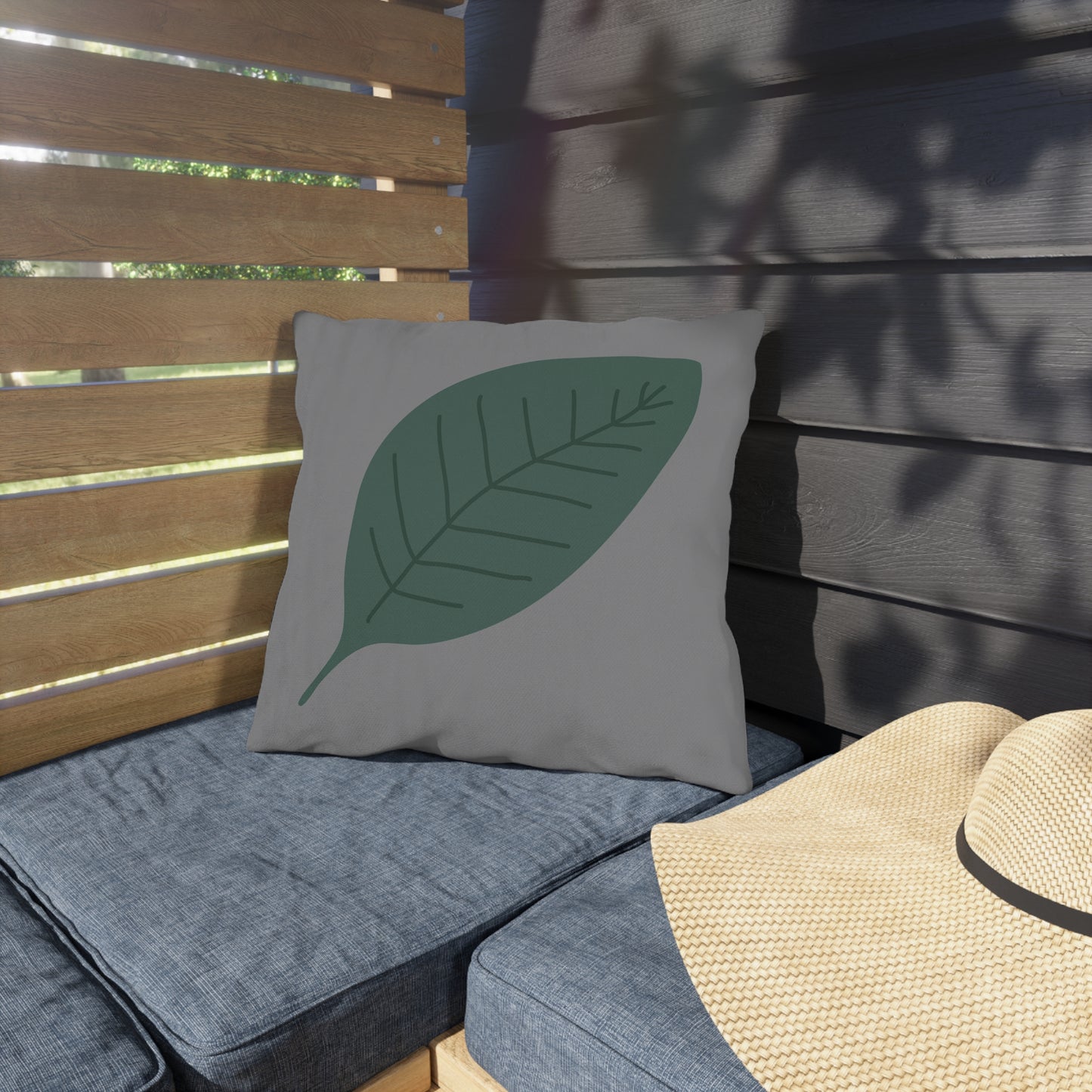 Gray cushion with a green leaf design on a wooden bench