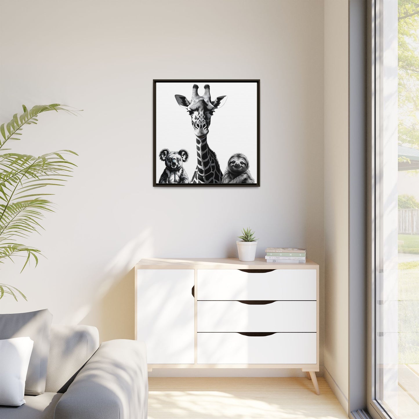Framed artwork of a giraffe with two dogs on a wall above a white cabinet.