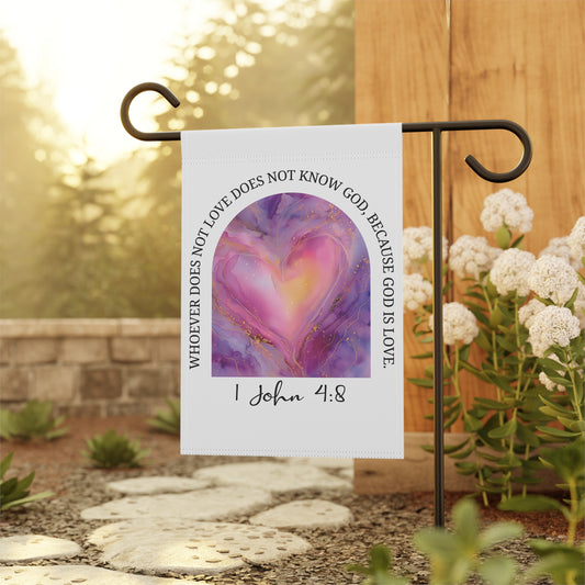 Garden flag with heart design and text on a stand outdoors.