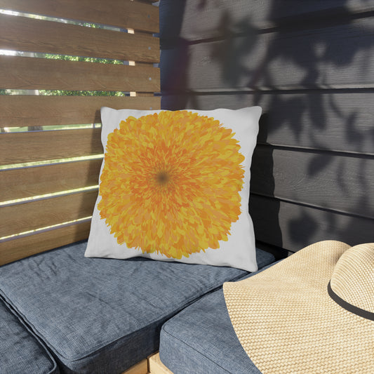 Decorative pillow with a yellow flower design on a gray cushioned bench.