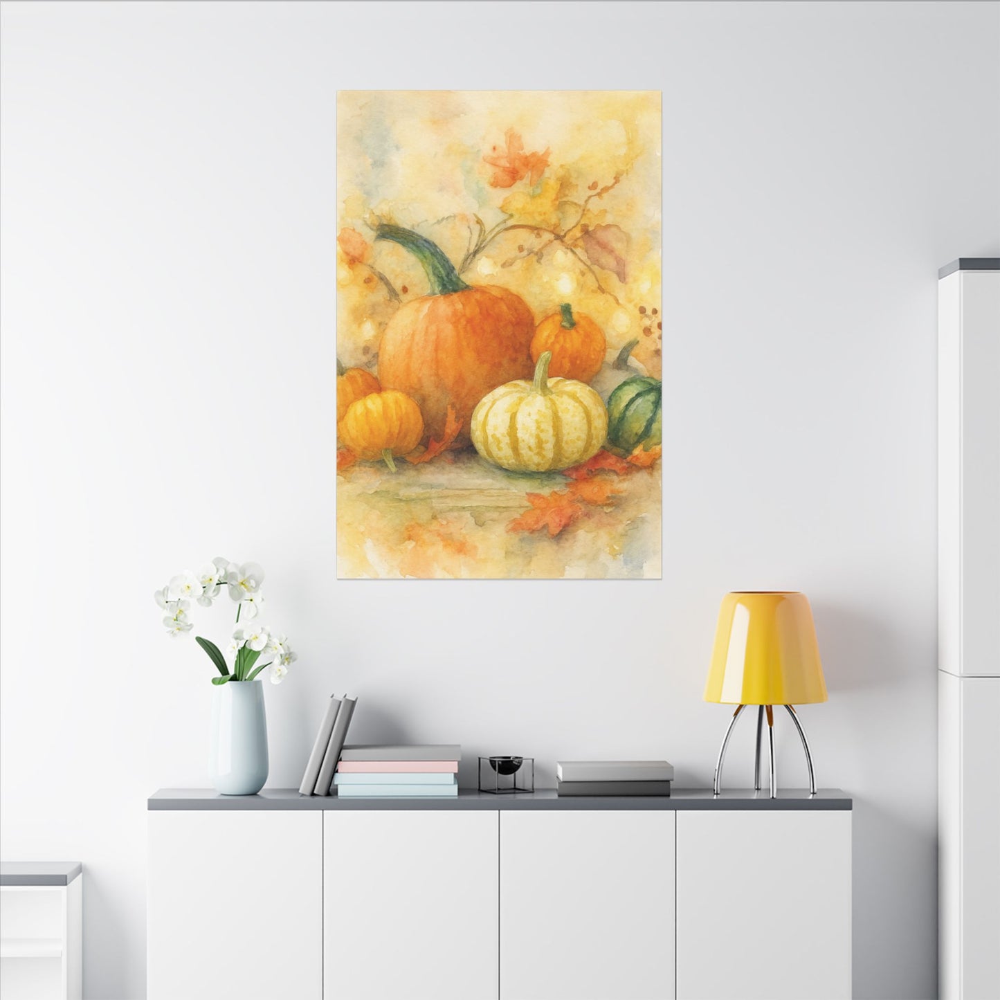 Canvas print of pumpkins and autumn leaves on a wall above a white cabinet.